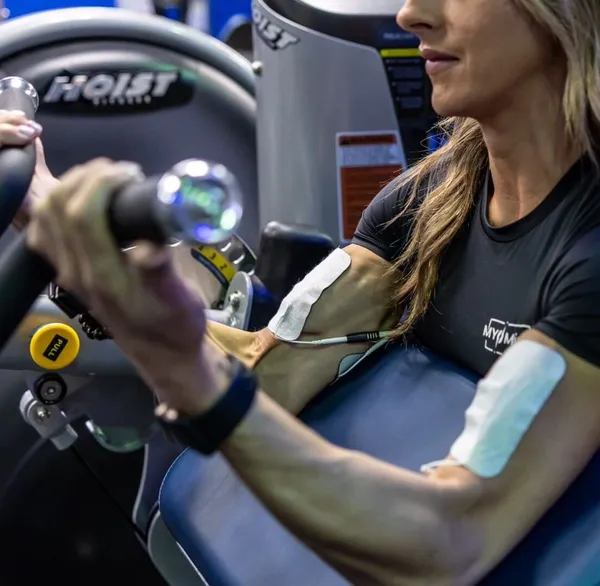 Jess doing biceps curl on Hoist machine with NXPro pads